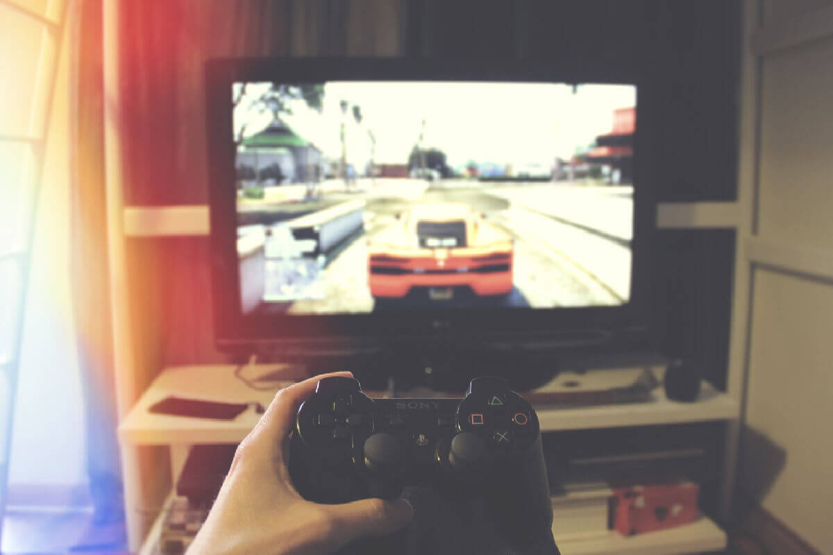 Close up of a Playstation controller playing a racing game