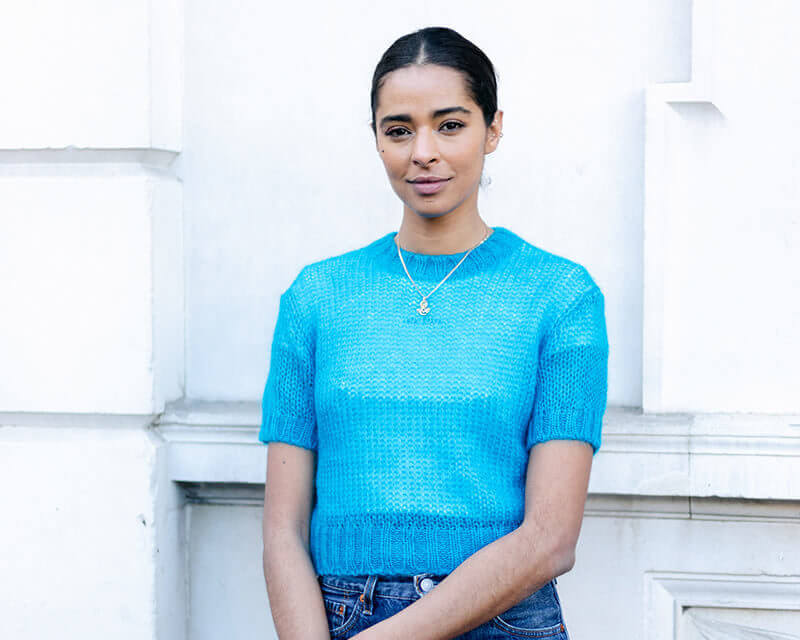 Woman wearing a bright blue top stood outside