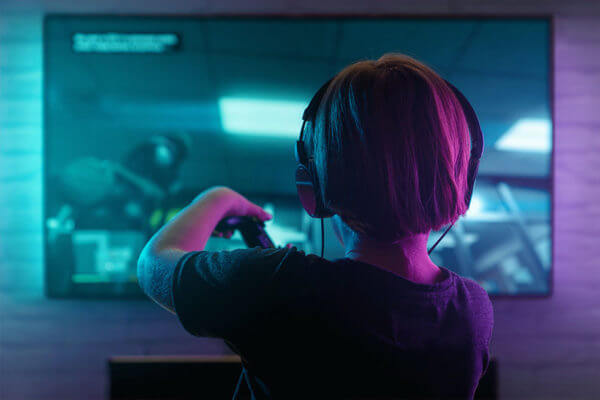 Kid playing a computer game wearing headphones