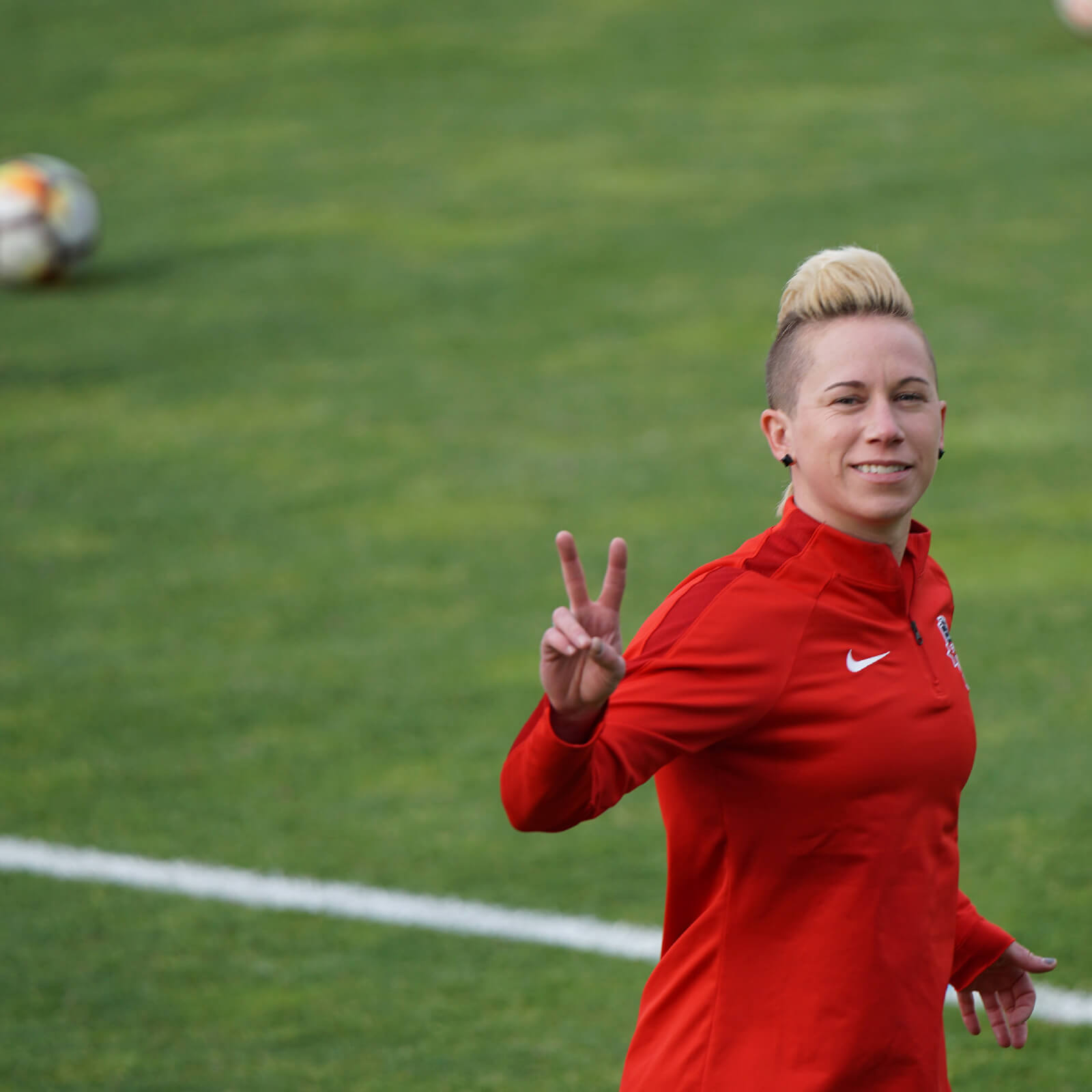 Footballer wearing red and giving a peace sign