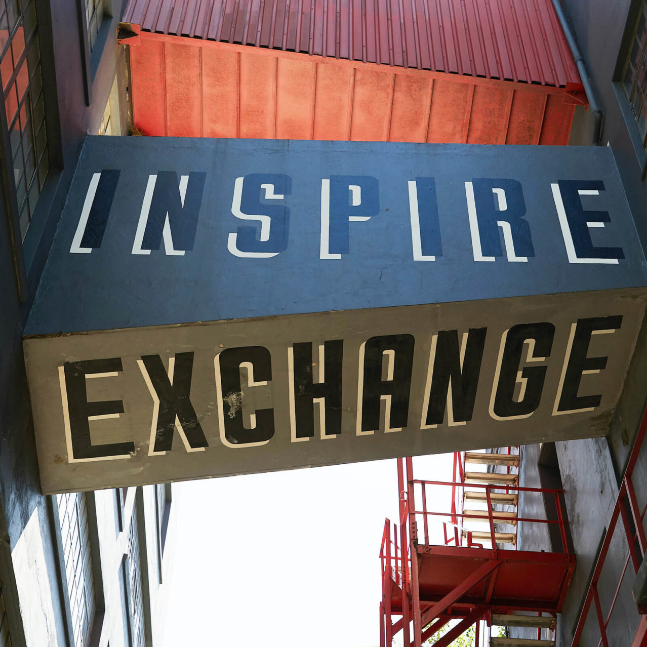 Inspire. Exchange. Typography painted onto an old warehouse style building.
