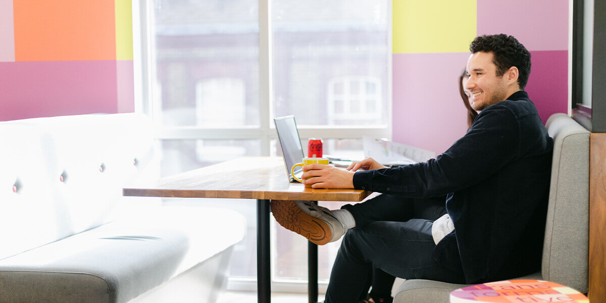 2 people looking at a laptop in a creative looking studio space.