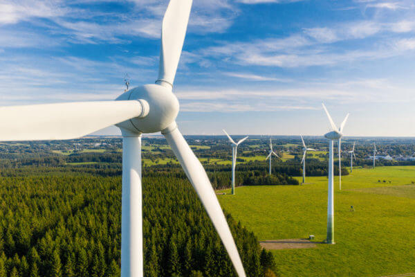 A landscape of blue skies, green grass and wind turbines