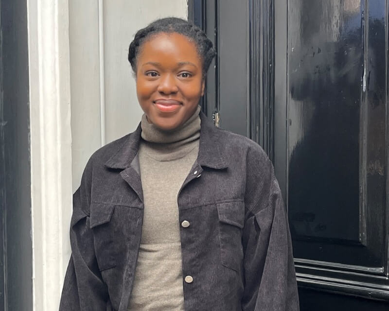 Woman stood in front of a black door