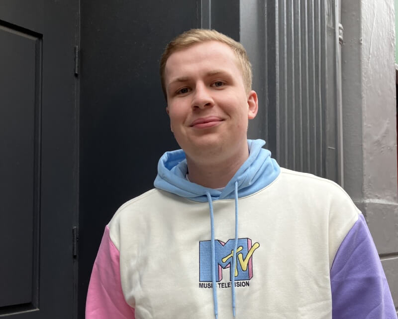 A man wearing an MTV hoody stood in a doorway.